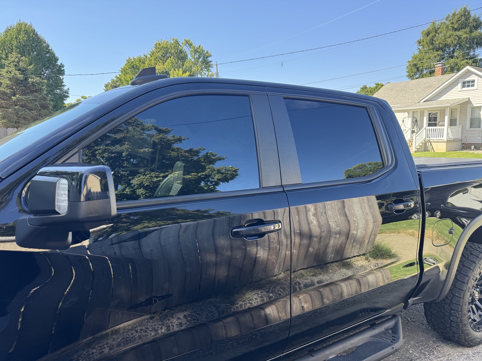 Driver-side view of black 2024 Chevrolet Silverado 1500 ZR2 with carbon tint on front and rear windows