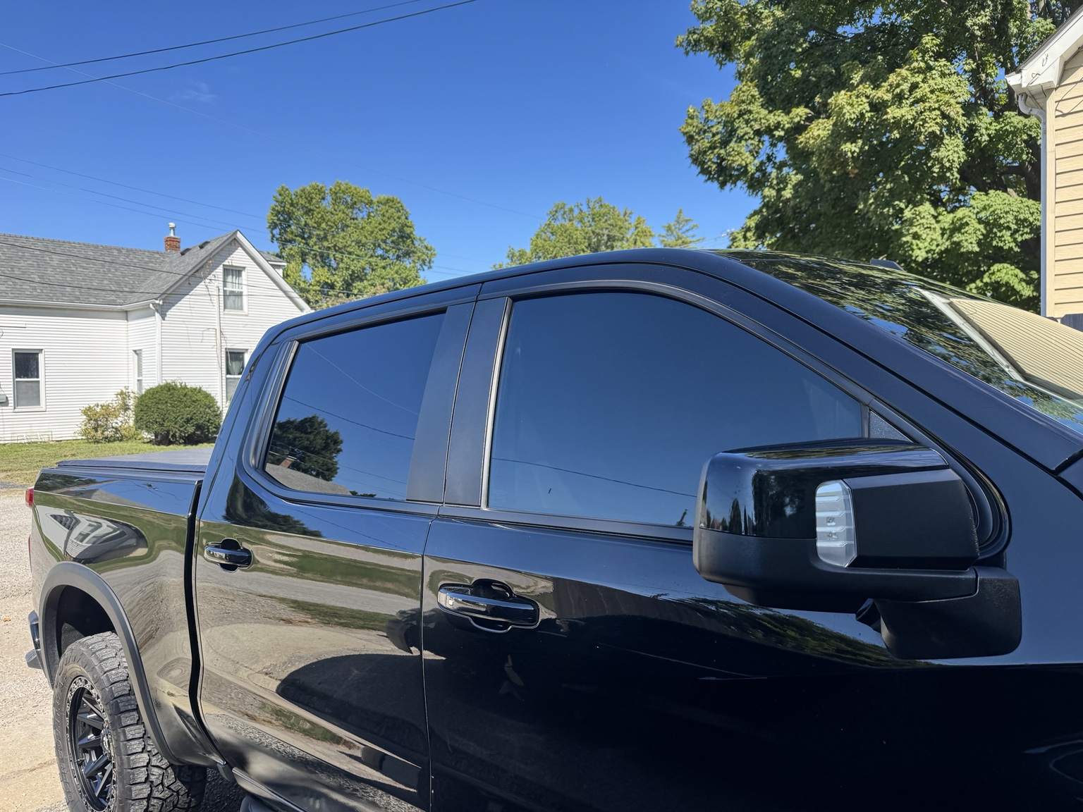 Passenger-side view of black 2024 Chevrolet Silverado 1500 ZR2 with carbon tint on front and rear windows